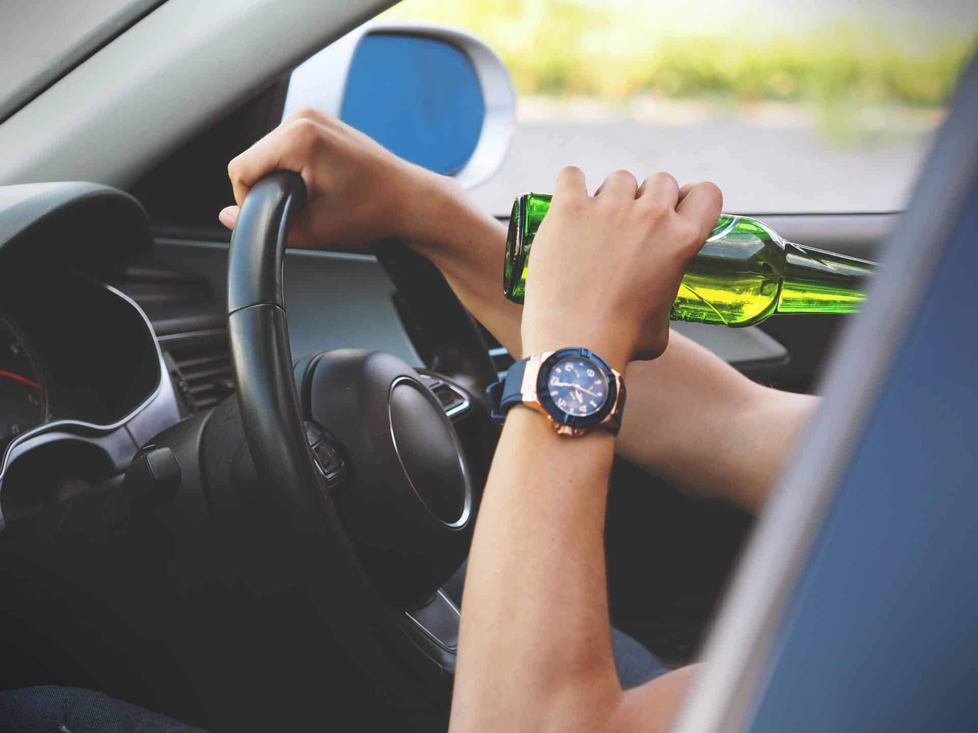 Person drinking a beer while driving.