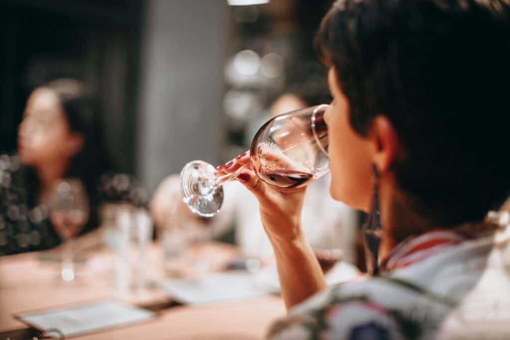 Lady drinking a glass of red wine.