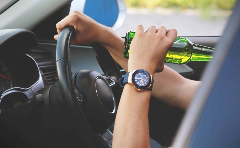 Person drinking a beer while driving.