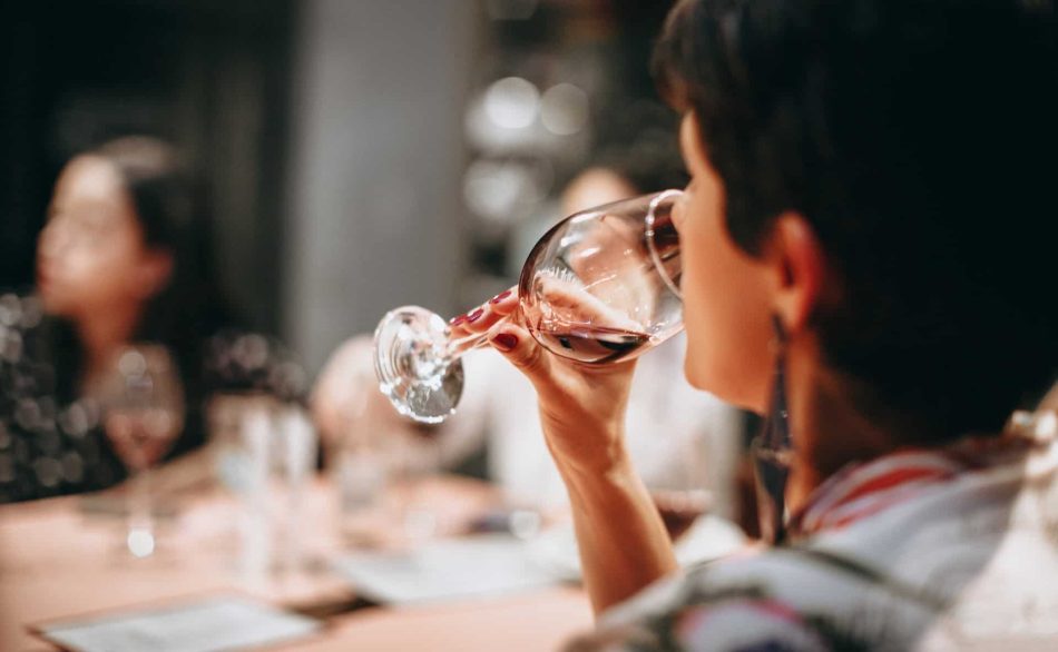 Lady drinking a glass of red wine.